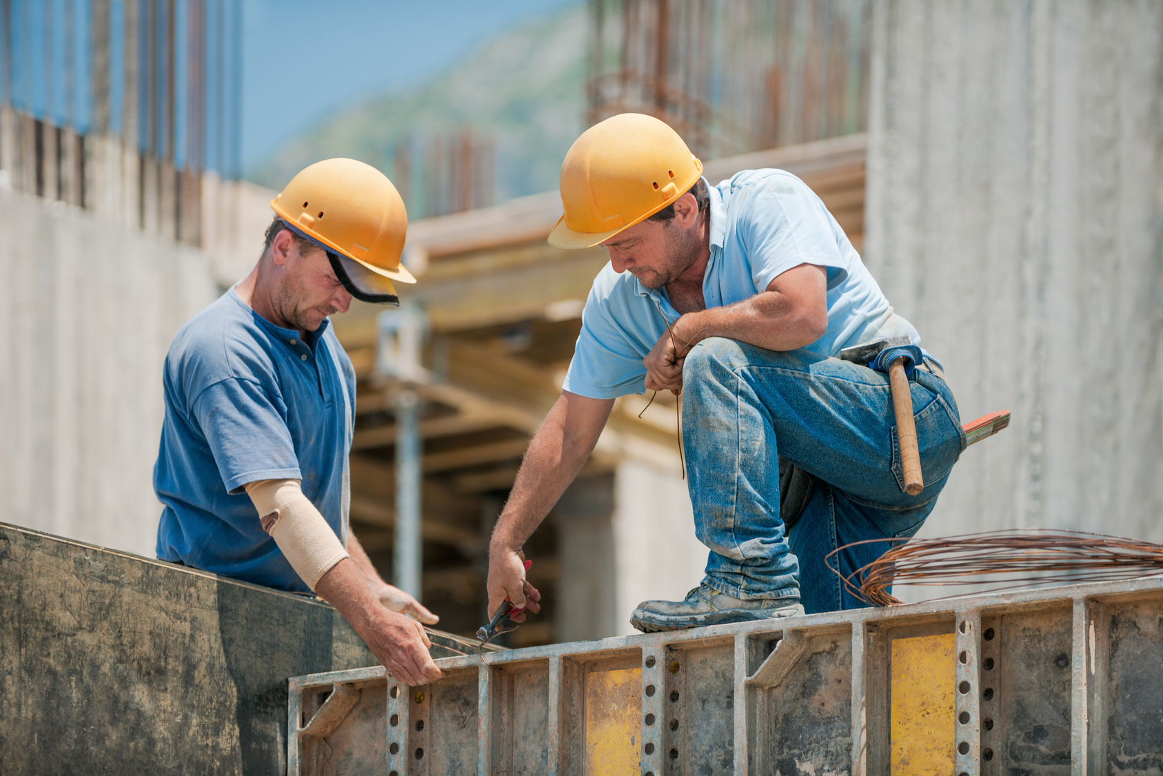two construction workers installing concrete formwork frames